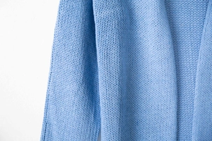 Detailed close-up of light blue chunky knit texture and soft V-shaped weaving patterns