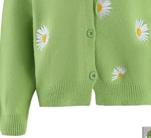Detail of green knitted cardigan showing delicate daisy embroidery and color-matched buttons
