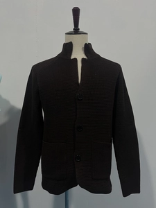 Detail of dark brown waffle knit cardigan featuring high collar and large black buttons