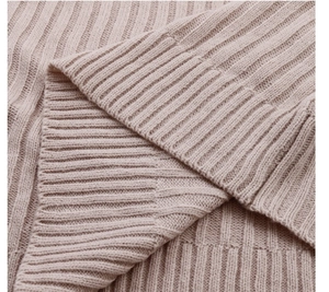 Detailed view of the fine ribbed knit texture on the soft beige knit dress sleeve
