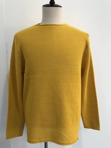 Dettaglio del maglione in maglia giallo senape con trama a nido d'ape e scollatura rotonda