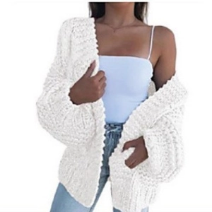 Women's oversized thick white knit cardigan with V-neck and long sleeves on model