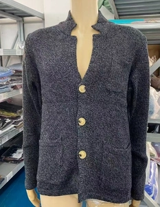 Detail of dark grey melange knit cardigan with three brown buttons and stand collar