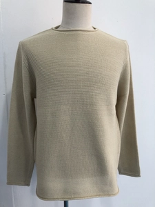 Dettaglio ravvicinato del maglione beige girocollo con trama a maglia fine e bordi rifiniti