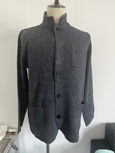 Detail of grey knitted cardigan showing stand collar, front buttons and textured fabric