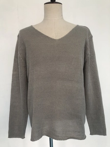 Detail of grey V-neck knit sweater showing lightweight texture and semi-sheer hemline