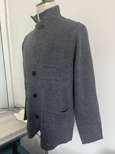 Detail of grey knitted cardigan with stand collar and textured button-down front