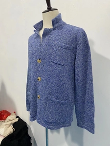 Detailaufnahme der blauen Strickjacke mit Holzknöpfen, Rippkragen und Fronttasche