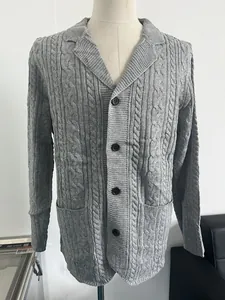 Detail of cable-knit texture and dark buttons on men's gray cardigan sweater