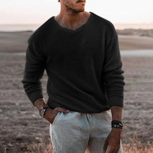 Detail of black waffle knit texture on men's long sleeve sweater with ribbed cuffs