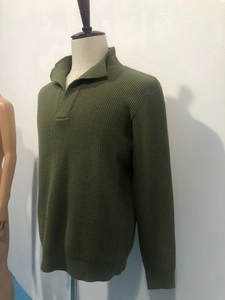 Detail of army green knit sweater showing coarse needle texture and high neck collar