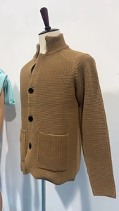 Close-up of brown waffle knit texture with high collar and large black buttons