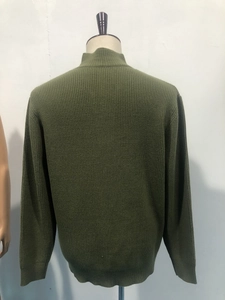 Detail view of olive green knit sweater showing ribbed cuffs and back texture