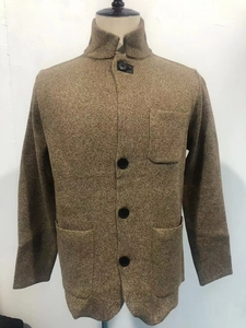 Close-up of tan knit cardigan showing stand collar, textured fabric and large buttons