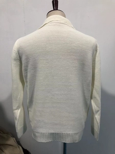 Detailed back view of a beige knit cardigan with ribbed cuffs and textured stitch pattern