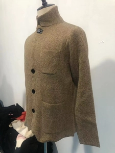 Detail of men's brown knit cardigan with stand collar and functional front pockets