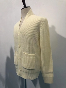 Detailed close-up of chunky knit texture and ribbed cuffs on the beige men cardigan