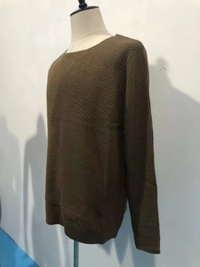 Detail of olive green men's sweater featuring textured waffle knit fabric and ribbed cuffs