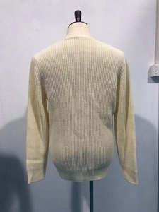 Detail of cream rib-knit cardigan showing stand collar and textured weave pattern on back