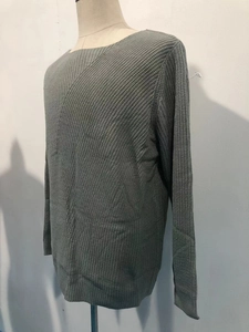 Detailed knit texture and ribbed cuff on a gray-green long sleeve waffle sweater