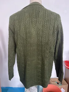 Detail of dark green cable knit pattern on thick men's cardigan for autumn winter