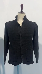 Detail of black waffle knit cardigan with stand collar and button-up pockets for men