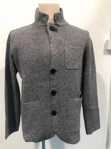 Close-up of grey knit cardigan with stand-up collar, three pockets, and black buttons