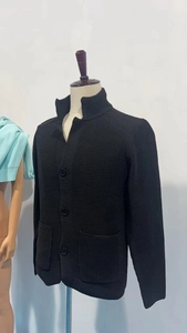 Detail of black waffle knit cardigan featuring stand collar and large front pockets