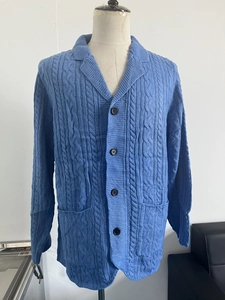Macro detail of blue cable knit cardigan featuring premium texture and lapel pocket