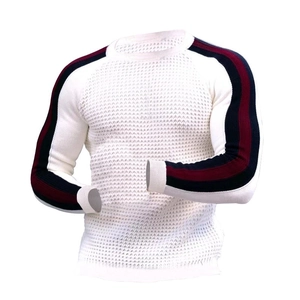 Détail d'un pull en maille blanc pour homme avec texture gaufrée et rayures sur les manches