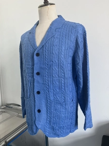 Macro shot of sky blue cable knit texture and large front pocket on cardigan sweater