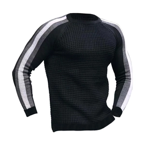 Détail de la maille gaufrée noire et des rayures grises sur la manche du pull