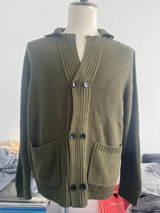 Detail shot of olive green knit cardigan with double-breasted buttons and ribbed cuffs