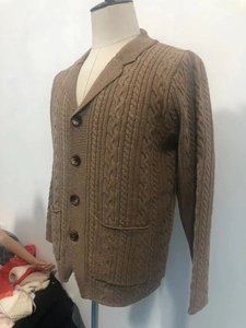 Close-up of khaki knit cardigan featuring classic cable texture and notched lapel buttons