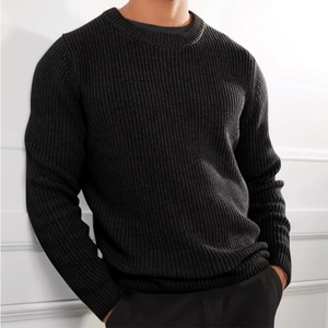 Close-up of black crew neck sweater showing thick ribbed knit texture and premium fabric