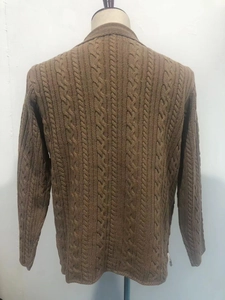 Detailed back view of a brown knit cardigan featuring classic chunky cable-stitch texture
