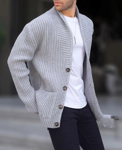 Detail of grey men's shawl collar cardigan showing chunky knit texture and brown buttons