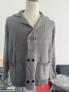 Detail of dark grey knit cardigan showing double-breasted buttons and ribbed texture