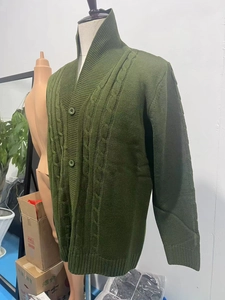 Dettaglio della maglia a trecce verde scuro e chiusura con bottoni sul cardigan uomo
