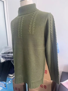 Detailed view of olive green cable knit turtleneck sweater with ribbed cuffs and hem
