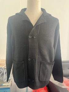 Detail of men's black knit cardigan featuring a shawl collar and double-breasted buttons