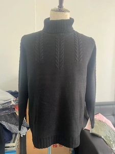Detail of cable knit pattern and ribbed cuff on a black turtleneck sweater for men
