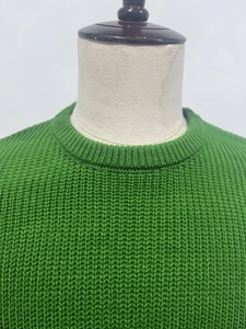 Detail of green waffle knit texture and ribbed crew neck on men's pullover sweater