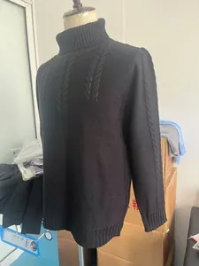 Close-up of black turtleneck sweater featuring thick cable knit texture for autumn warmth