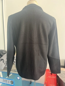 Back view of black knit cardigan featuring wide ribbed hem and sleeve cuffs detail