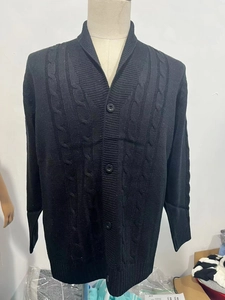 Dettaglio macro di un cardigan da uomo nero in maglia a trecce con collo a scialle