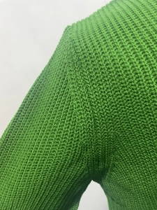 Detail view of the green men's knitted sweater showing thick waffle weave texture on the shoulder