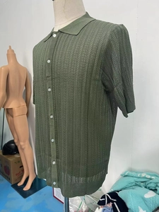 Detail of the dark green knit polo shirt featuring vertical hollow breathable texture and buttons