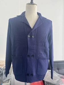 Detail of navy knit cardigan showing shawl collar, double-breasted buttons and texture