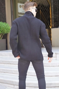 Close-up of men's black turtleneck sweater featuring thick vertical ribbed knit texture